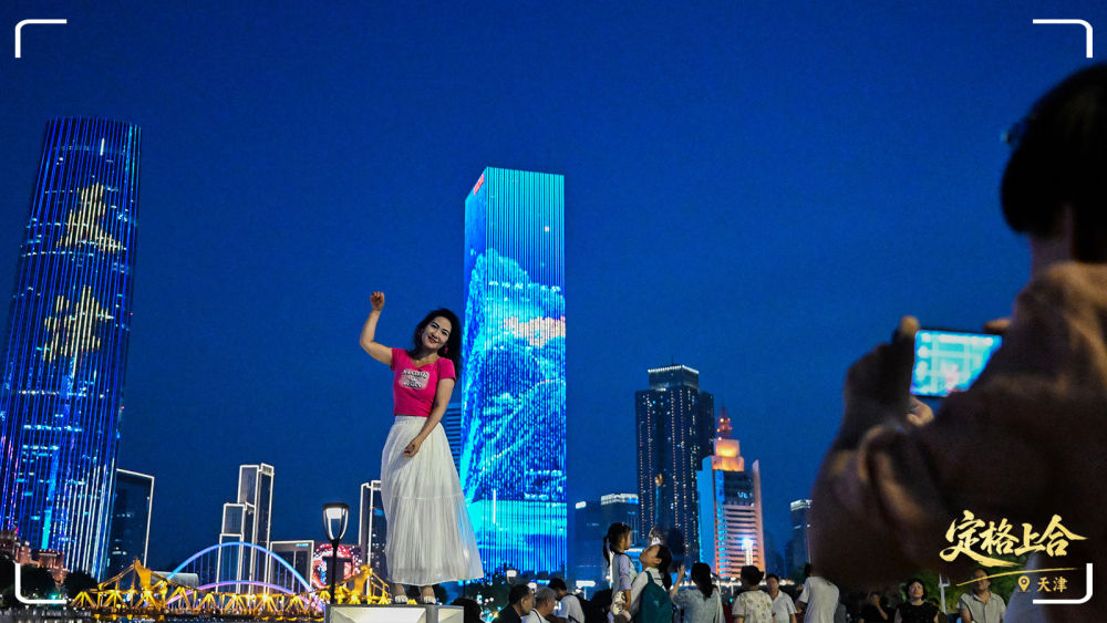 游客在天津市的海河岸邊拍照打卡。