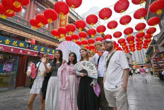 8月14日，上合組織國家學生在天津古文化街留影。新華社記者李然攝